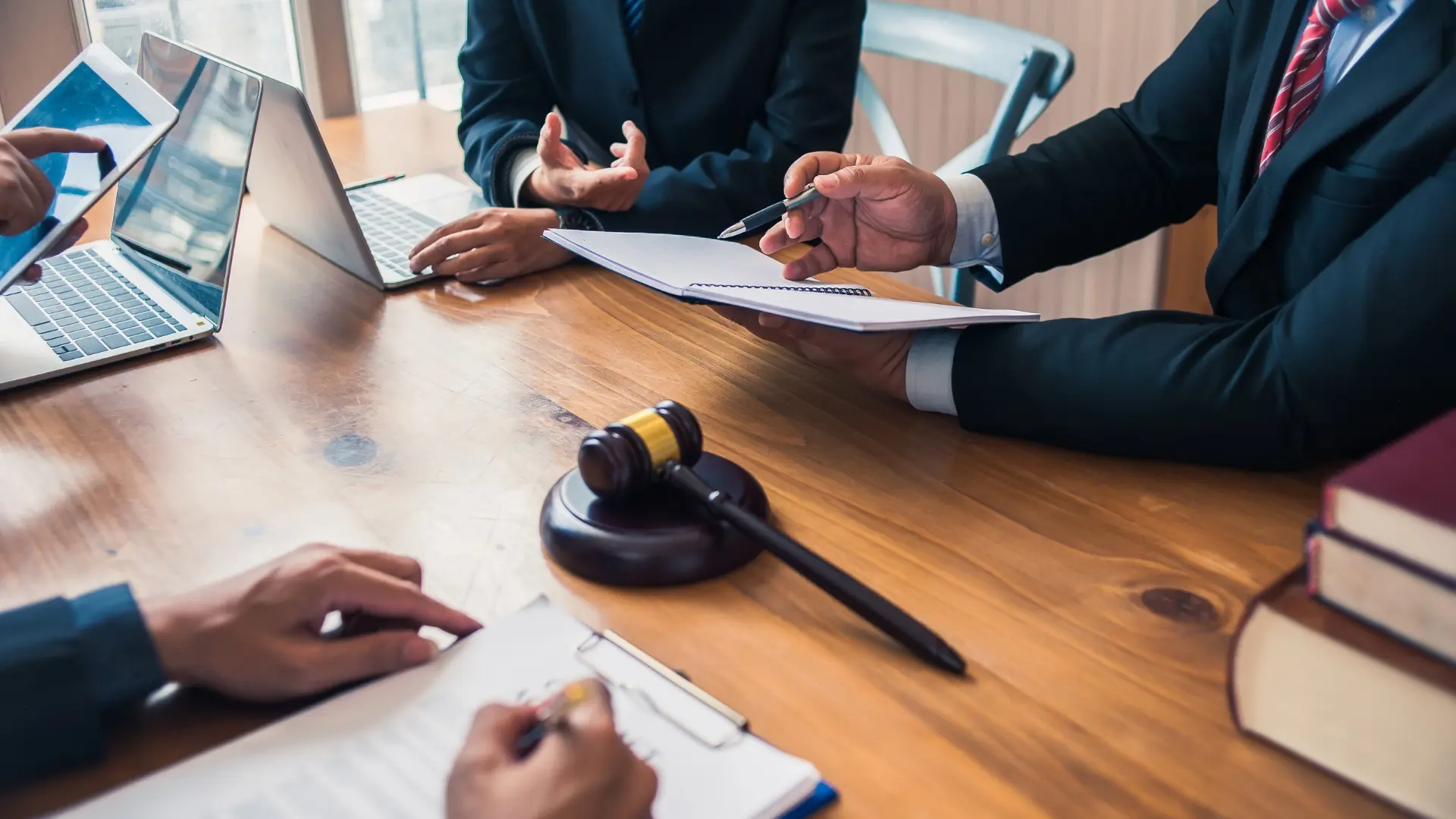 Lawyers discussing legal documents with a gavel on the table.